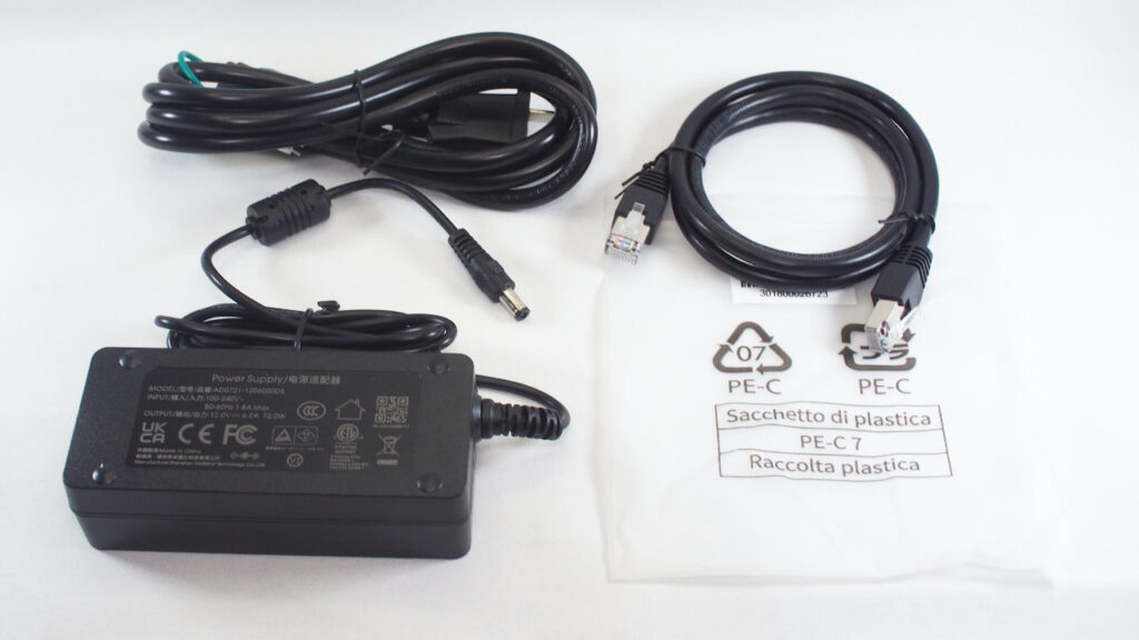 付属品のACアダプターと電源ケーブル、Cat6規格のLANケーブル。